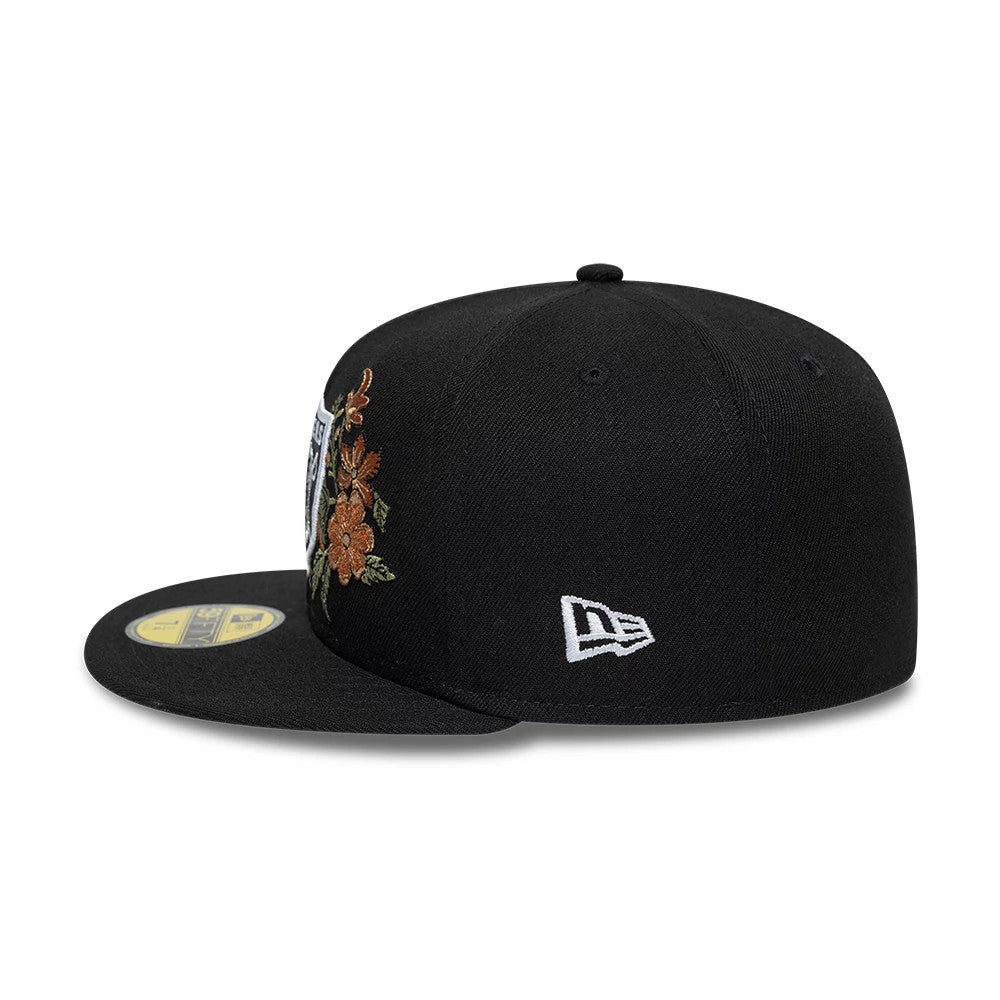 Las Vegas Raiders NFL Floral Black New Era 59FIFTY Fitted Cap, side view showing the white New Era flag logo on the left side, with orange floral embroidery on the front panel and a gold 59FIFTY size sticker on the black visor.