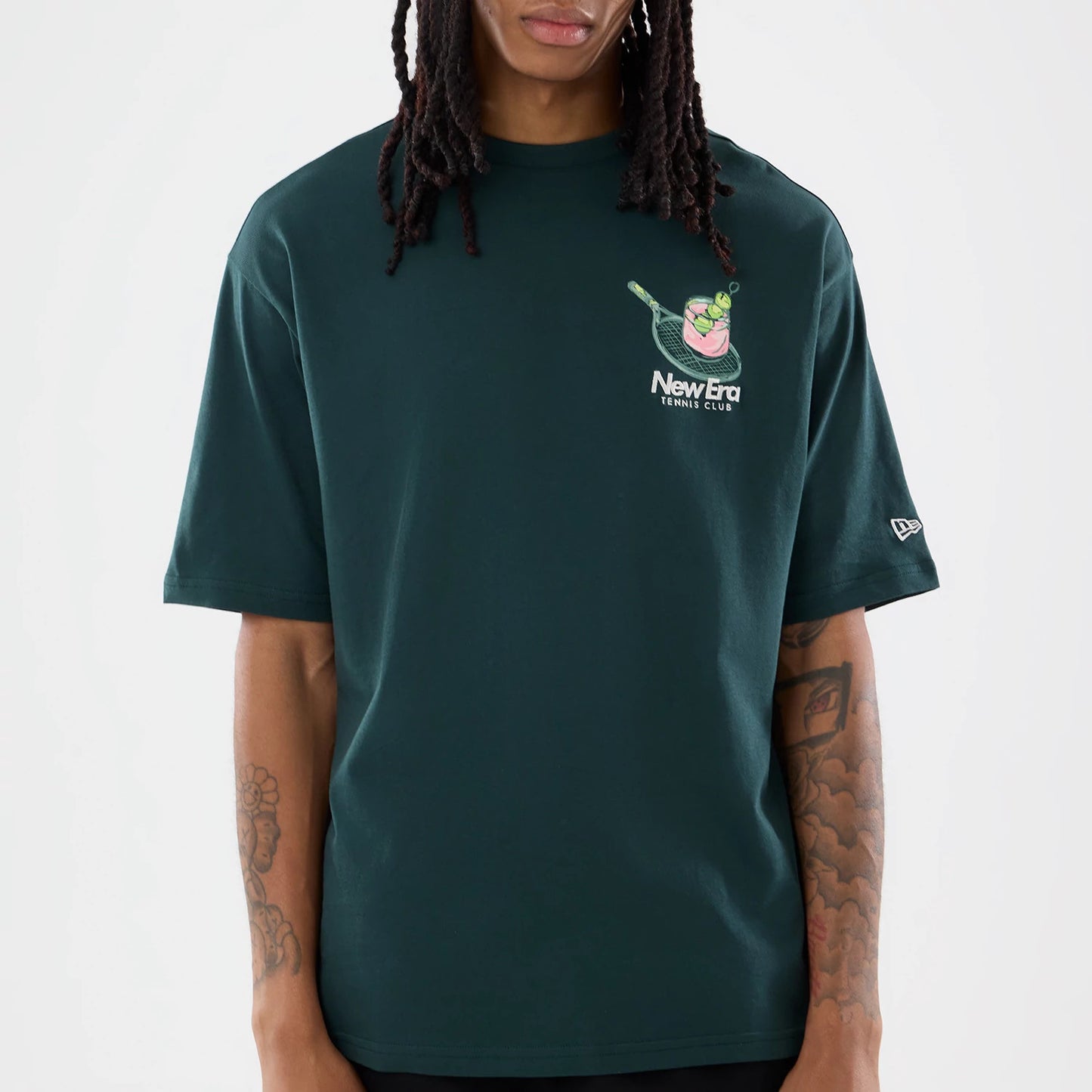 The model is wearing this New Era Tennis Graphic Oversized T-Shirt in dark green. 5