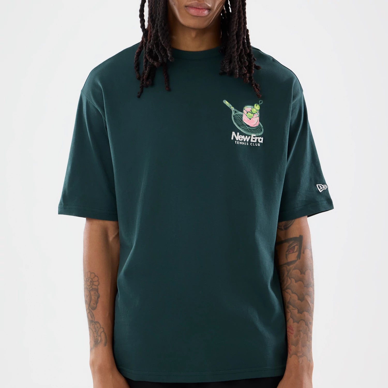 The model is wearing this New Era Tennis Graphic Oversized T-Shirt in dark green. 5