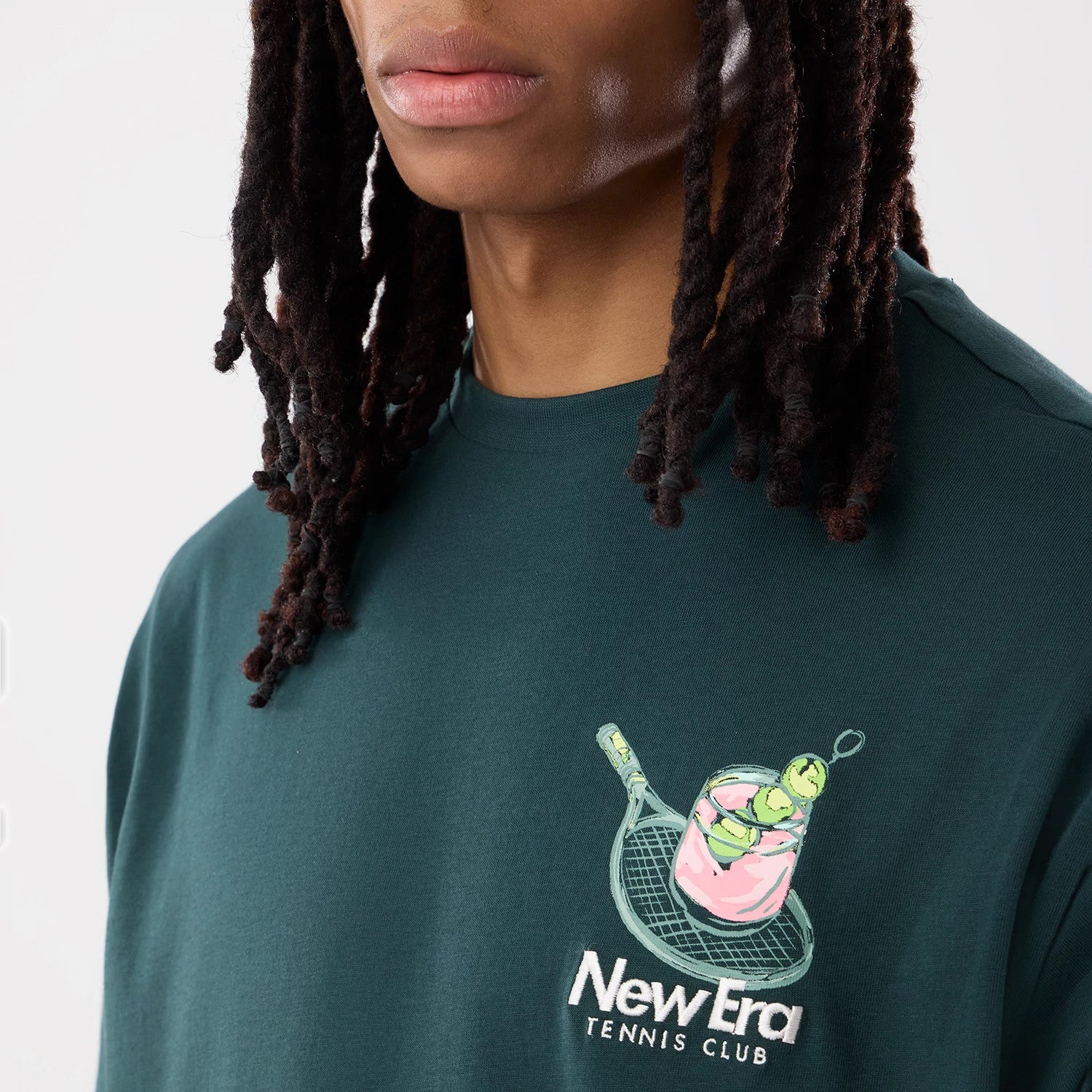 The model is wearing this New Era Tennis Graphic Oversized T-Shirt in dark green. 6