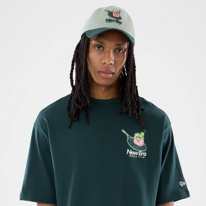 The model is wearing this New Era Tennis Graphic Oversized T-Shirt in dark green. 3