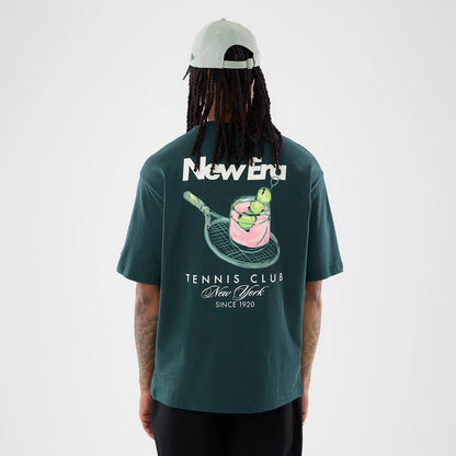 The model is wearing this New Era Tennis Graphic Oversized T-Shirt in dark green. 2