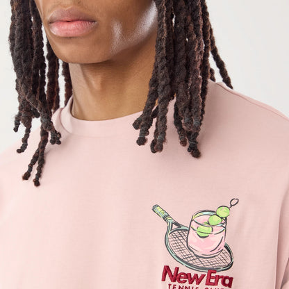The model is wearing this New Era Tennis Graphic Oversized T-Shirt in pastel pink. 6