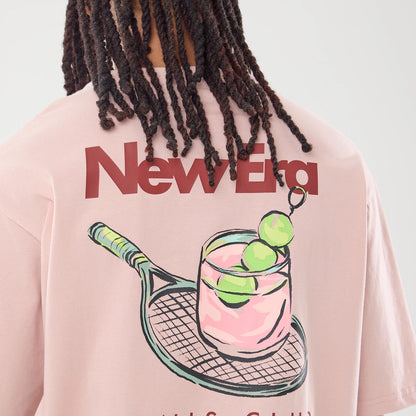 The model is wearing this New Era Tennis Graphic Oversized T-Shirt in pastel pink. 4