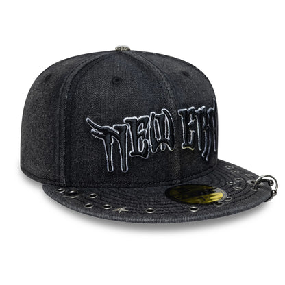 New Era Hardware Washed Black New Era 59FIFTY Fitted Cap, three-quarter view showing the raised white embroidered New Era wordmark on the front panels, studded black visor with eyelets, and a gold 59FIFTY size sticker.