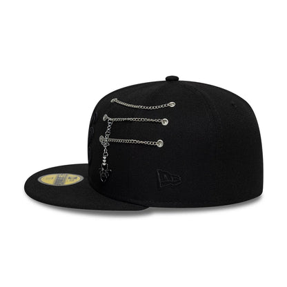 New Era Spider Pin Chain Black 59FIFTY Fitted Cap, side view showing a chrome pin and chain detail across the eyelets on the side panel, black embroidered New Era flag logo on the left side, and black flat visor with gold 59FIFTY size sticker.