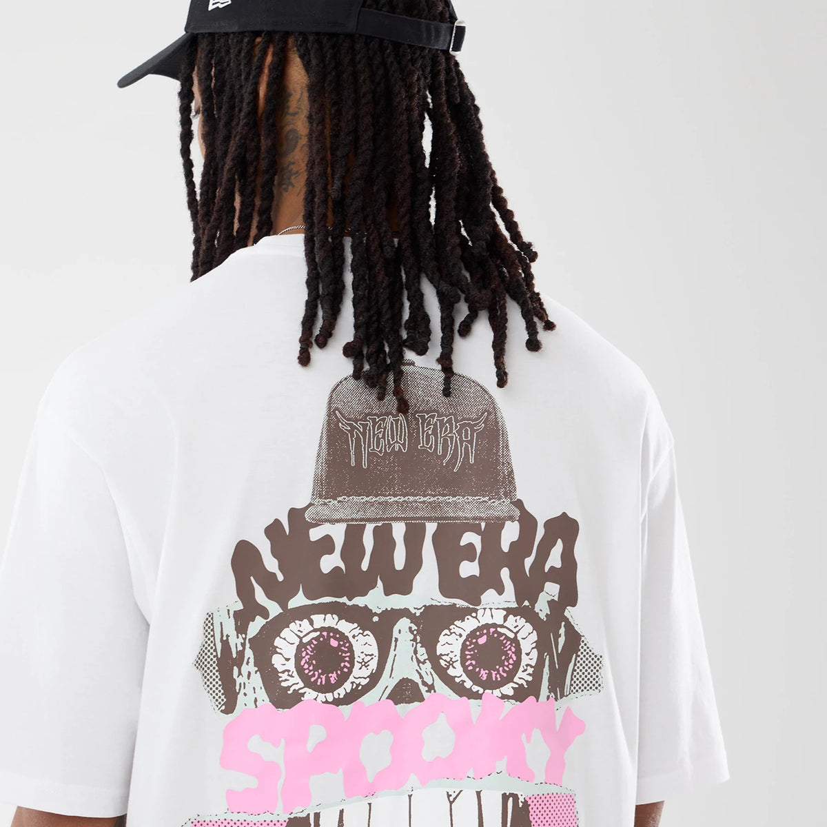 The model is wearing this New Era Spooky Graphic Oversized T-Shirt in white. 7