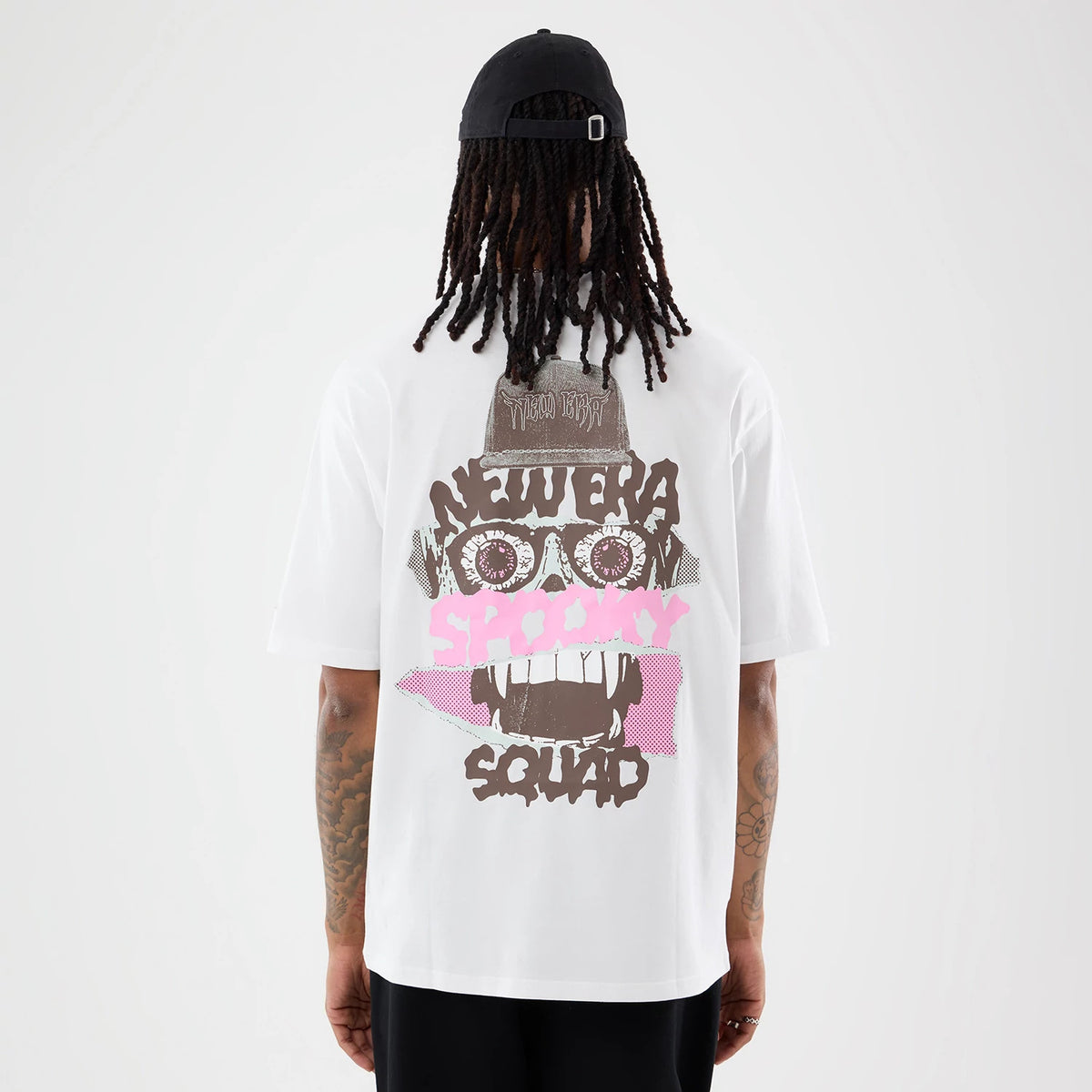 The model is wearing this New Era Spooky Graphic Oversized T-Shirt in white. 2