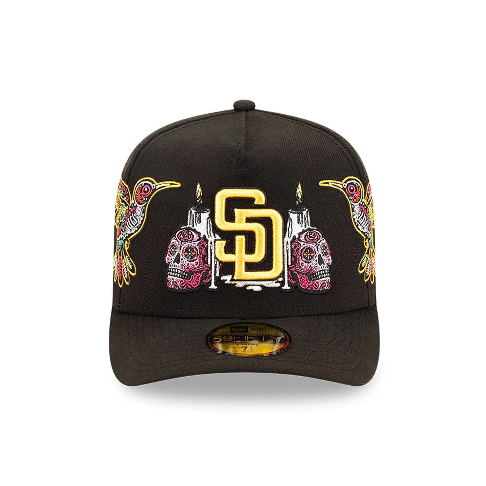 San Diego Padres MLB Day Of The Dead Black New Era 59FIFTY A-Frame Fitted Cap, front view showing an ornate yellow embroidered SD logo on the black structured crown, flanked by colourful candles, skulls, and birds.