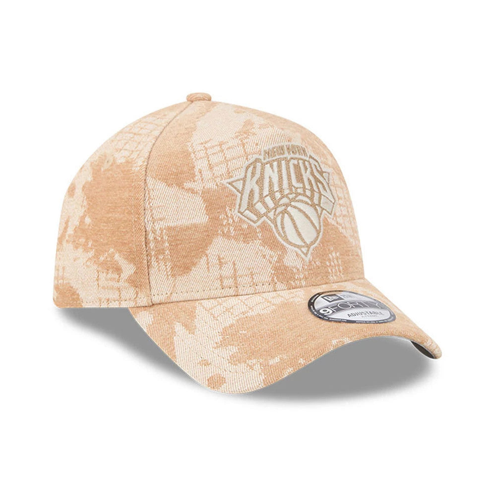 New York Knicks NBA Fall Story Beige New Era 9FORTY A-Frame Adjustable Cap, three-quarter view showing the front panel with a white embroidered Knicks logo, a curved beige visor, and a 9FORTY size sticker on the visor.