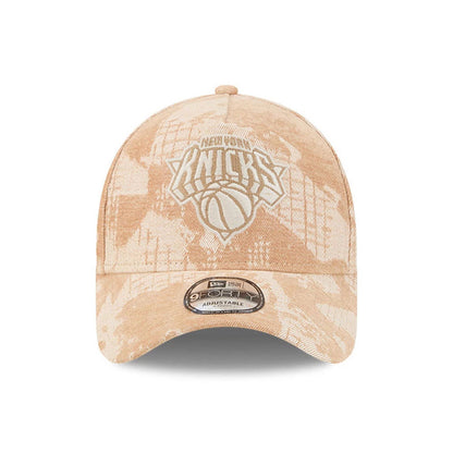 New York Knicks NBA Fall Story Beige New Era 9FORTY A-Frame Adjustable Cap, front view showing the white embroidered Knicks logo on the centre of the structured beige crown with a beige camo pattern and a 9FORTY size sticker on the curved visor.