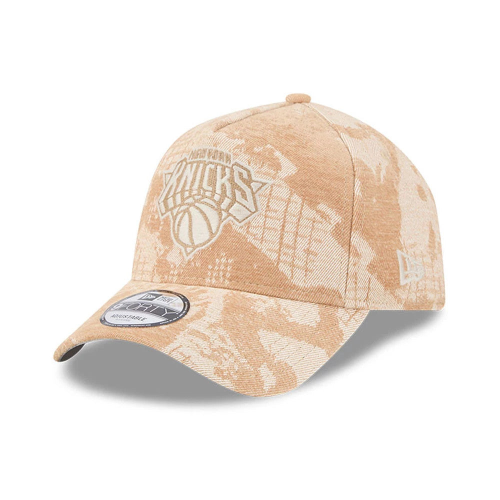 New York Knicks NBA Fall Story Beige New Era 9FORTY A-Frame Adjustable Cap, three-quarter view showing the light beige embroidered Knicks logo on the front panel, with a beige and cream abstract pattern.