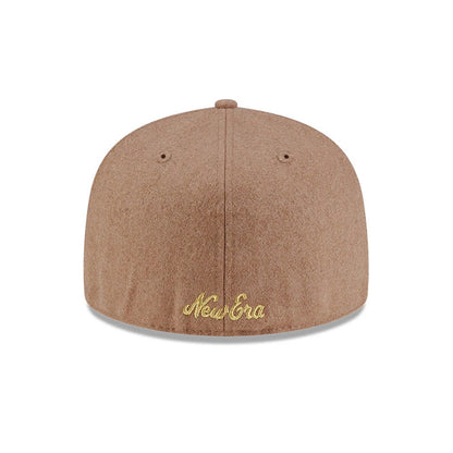 New Era X Omerta Balvin Beige New Era 59FIFTY Fitted Cap, rear view showing the gold embroidered New Era script logo centred low on the structured beige crown, with matching eyelets and a top button for a cohesive look.