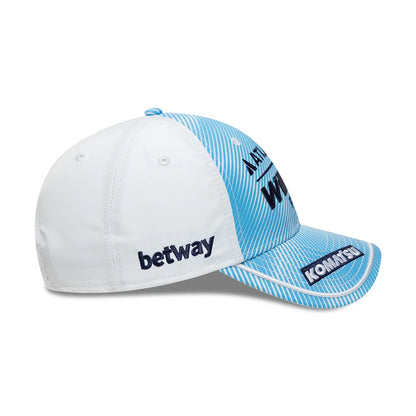 Williams Spain Race Special Blue New Era 9FORTY Adjustable Cap, side view showing the dark blue embroidered betway logo on the white crown, light blue striped front panel and visor with Komatsu branding, and a small blue top button.