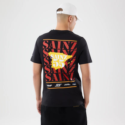New Era Williams Carlos Sainz Spain Race Special Black T-Shirt, back view on a model showing red Sainz repeated text graphics and a yellow map of Spain with '55' over it, paired with dark trousers and a white cap.