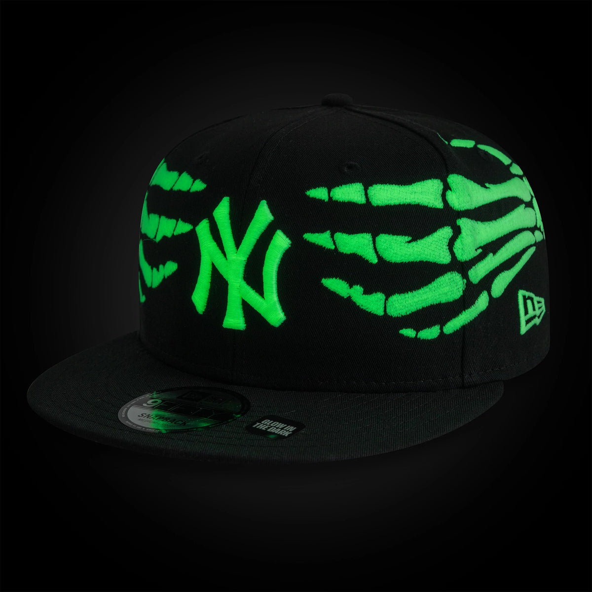 Yankees MLB Halloween Glow In The Dark Hands Black New Era 9FIFTY Snapback Adjustable Cap, three-quarter view showing the green glow-in-the-dark skeletal hand graphics on the black crown, raised green NY logo on the front panel.