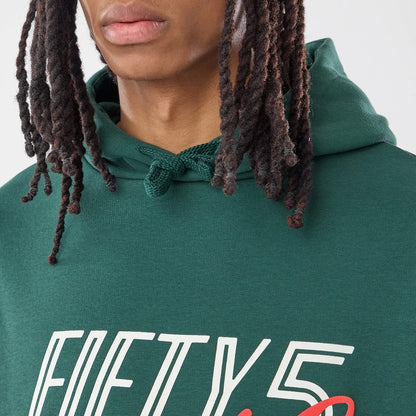 The model is wearing this Carlos Sainz Team Fifty5 Smooth Oversized Pullover Hoodie in dark green. 3