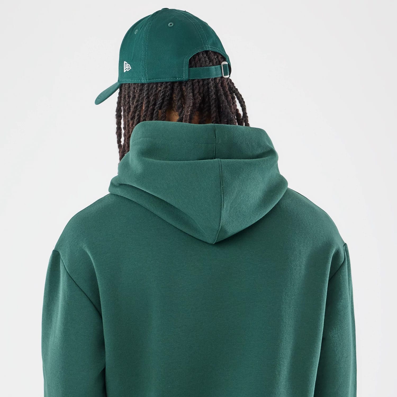 The model is wearing this Carlos Sainz Team Fifty5 Smooth Oversized Pullover Hoodie in dark green. 7