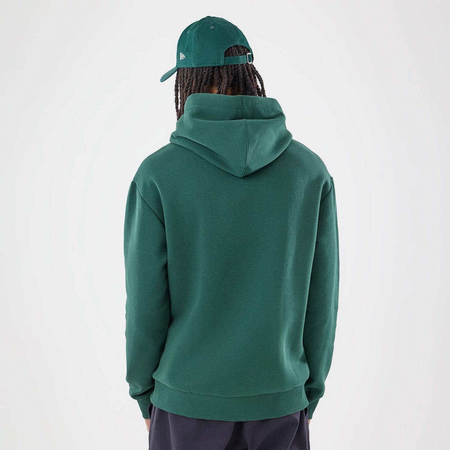 The model is wearing this Carlos Sainz Team Fifty5 Smooth Oversized Pullover Hoodie in dark green. 2