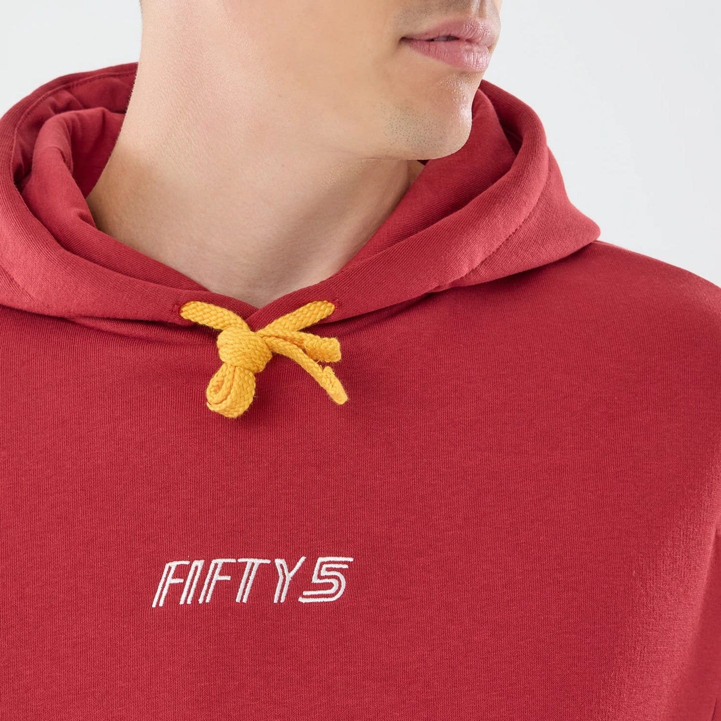 The model is wearing this Carlos Sainz Team Fifty5 Madrid Oversized Pullover Hoodie in dark red. 4