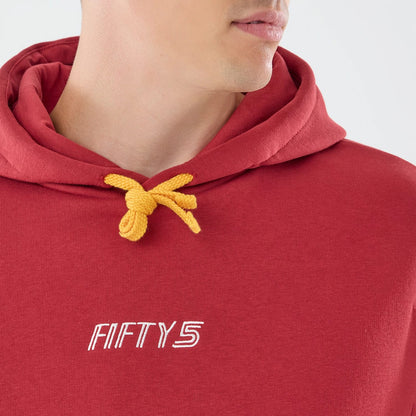 The model is wearing this Carlos Sainz Team Fifty5 Madrid Oversized Pullover Hoodie in dark red. 4