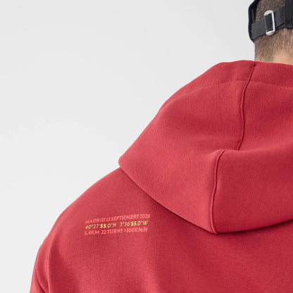 The model is wearing this Carlos Sainz Team Fifty5 Madrid Oversized Pullover Hoodie in dark red. 7