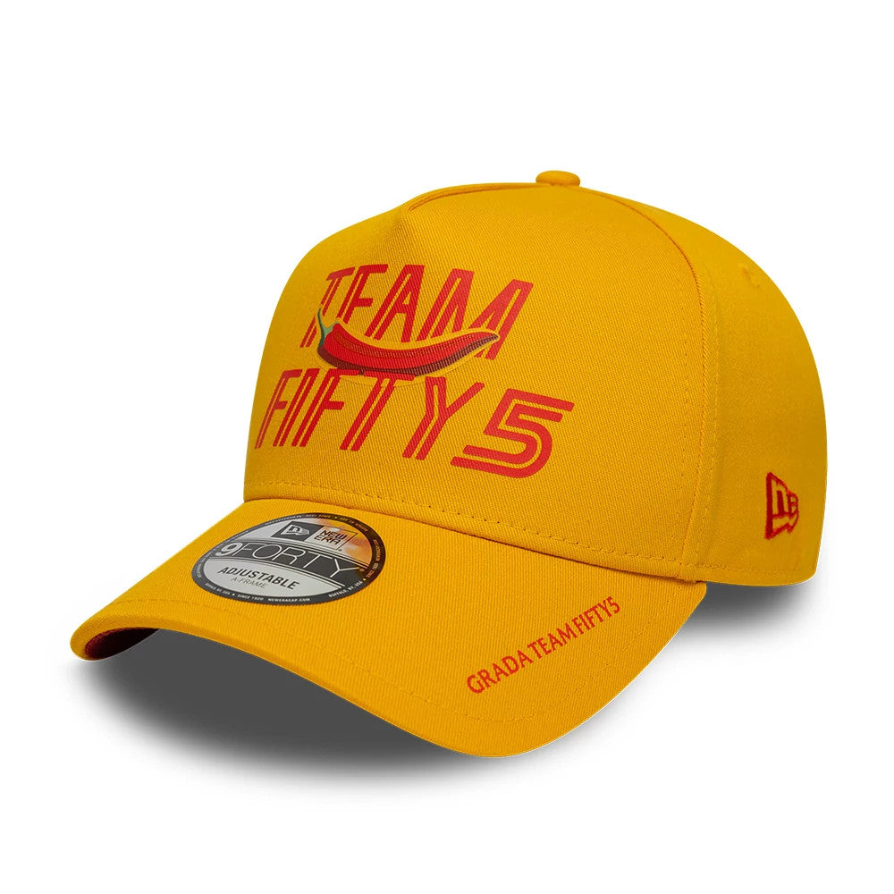 Carlos Sainz Team Fifty5 Grandstand Dark Yellow New Era 9FORTY A-Frame Adjustable Cap, three-quarter view showing the red embroidered Team Fifty5 graphic on the front panel, a matching New Era flag logo on the left side.