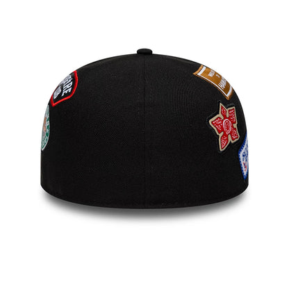 Netflix Stranger Things 10 Years Black New Era 59FIFTY Fitted Cap, rear view showing multiple colourful embroidered patches on the structured black crown, including a red floral design and brown rectangular badge, with no centre back logo.