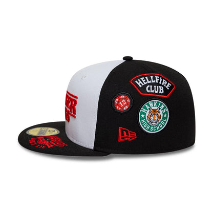 Netflix Stranger Things 10 Years Black New Era 59FIFTY Fitted Cap, side view showing multiple embroidered patches including Hawkins High School and Hellfire Club on the black crown, with a contrasting white front panel and a black flat visor.