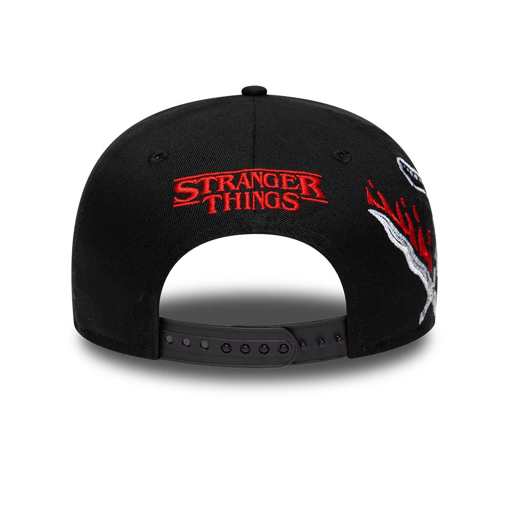 Netflix Stranger Things Hellfire Lives Black New Era 9FIFTY Snapback Adjustable Cap, rear view showing the embroidered red Stranger Things logo on the centre back, with contrasting black snap closure and graphic details extending along the sides.