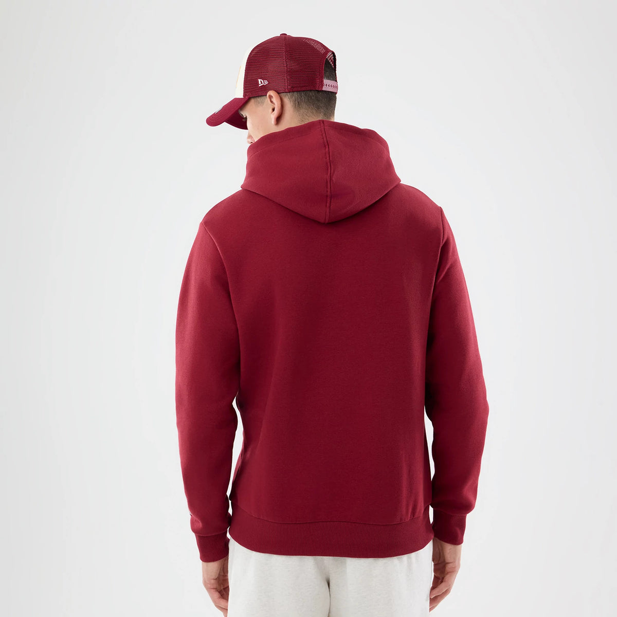 The model is wearing this NFL Patch Washington Commanders Pullover Hoodie in dark red. 2