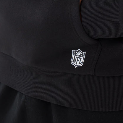 New Era Detroit Lions NFL Patch Black Pullover Hoodie, side view showing a small white embroidered NFL shield logo near the ribbed hem, the hoodie’s black fabric, and stitching details around the pocket area.