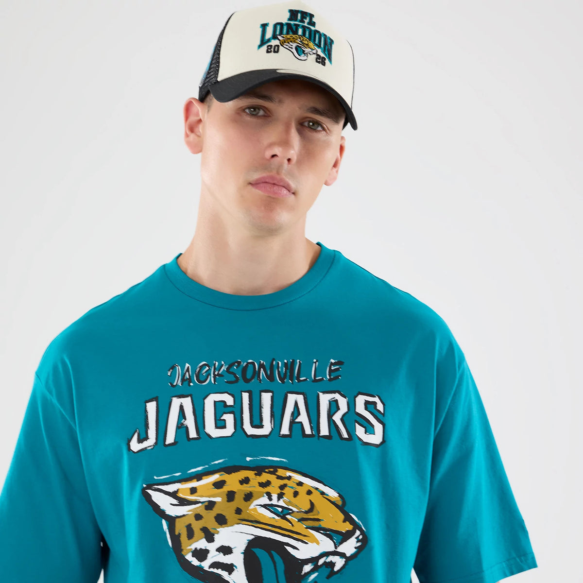 New Era Jacksonville Jaguars NFL Graphic Slogan Turquoise Oversized T-Shirt, front view on-model showing jaguar’s head graphic and textured Jacksonville Jaguars lettering across the chest.