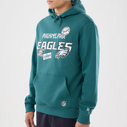 The model is wearing this NFL International Games 2026 Philadelphia Eagles Pullover Hoodie in dark green. 3
