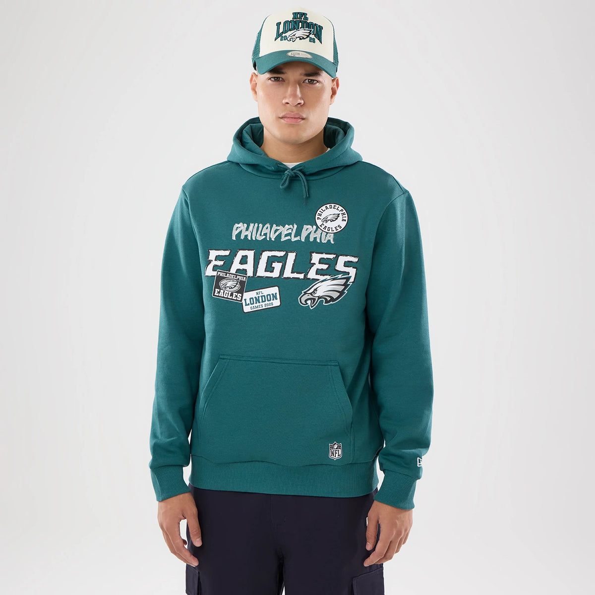 The model is wearing this NFL International Games 2026 Philadelphia Eagles Pullover Hoodie in dark green. 1