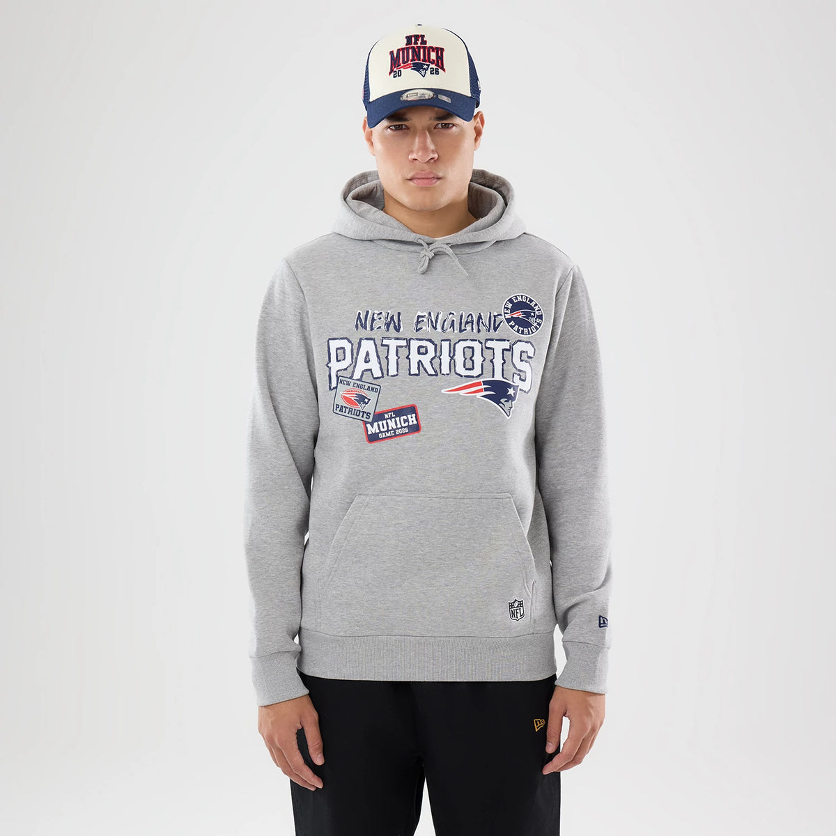 The model is wearing this NFL International Games 2026 New England Patriots Pullover Hoodie in grey. 1