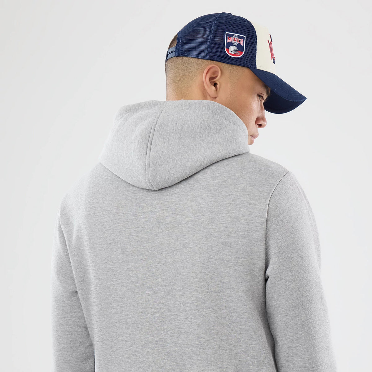 The model is wearing this NFL International Games 2026 New England Patriots Pullover Hoodie in grey. 7