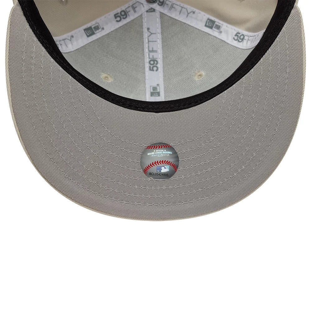 Chicago White Sox MLB Beige New Era 59FIFTY Fitted Cap, inside view showing the grey undervisor with a baseball-themed sticker, 59FIFTY branded taping across the crown, and beige sweatband lining around the interior.