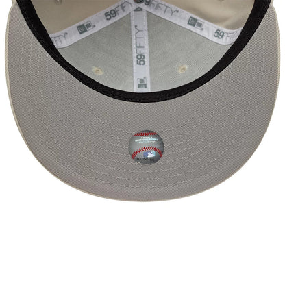 Chicago White Sox MLB Beige New Era 59FIFTY Fitted Cap, inside view showing the grey undervisor with a baseball-themed sticker, 59FIFTY branded taping across the crown, and beige sweatband lining around the interior.
