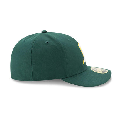 Athletics Authentic Collection Low Profile New Era 59FIFTY, side view showing the green structured crown with matching flat visor, yellow embroidered logo partially on the front panel, and gold 59FIFTY size sticker on the visor.