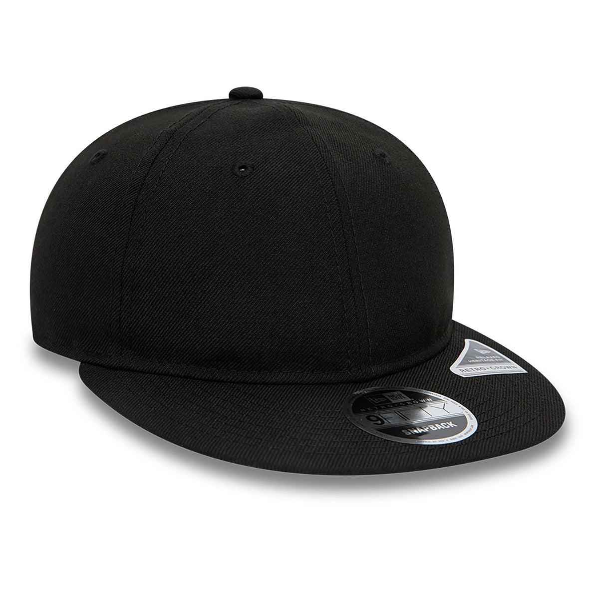 Blank New Era Black Retro Crown 9FIFTY Snapback Cap, three-quarter view showing a flat black visor with a 9FIFTY size sticker, a structured crown with small black eyelets, and a New Era flag logo on the left side.