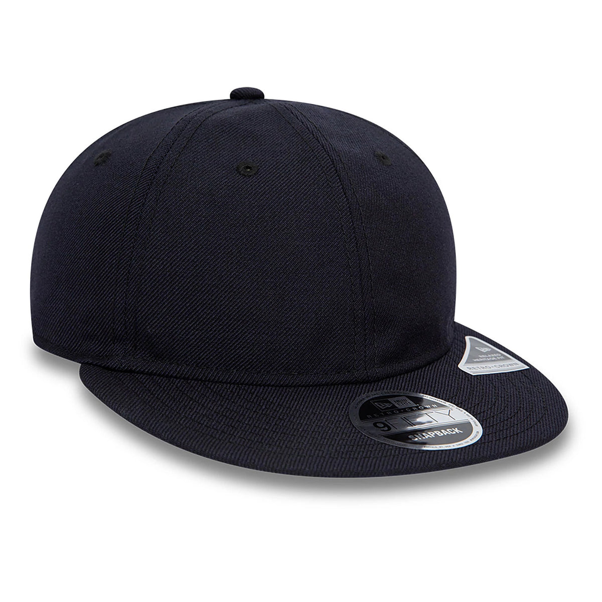 Blank New Era Navy Retro Crown 9FIFTY Snapback Cap, three-quarter view showing a flat navy visor with a black and silver 9FIFTY size sticker, embroidered navy eyelets on the structured crown, and a New Era flag logo on the left side.