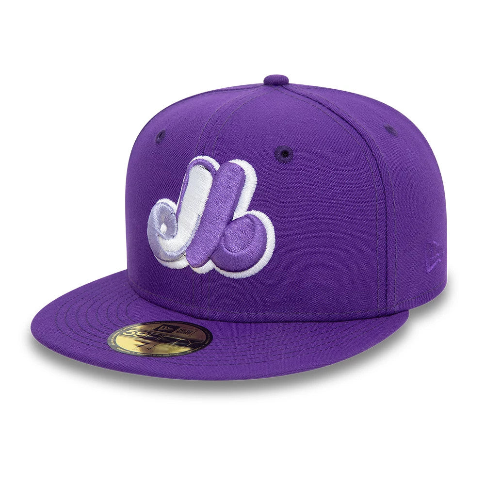 Montreal Expos All Star Game Purple New Era 59FIFTY Fitted Cap, front view showing a large white and purple embroidered logo on the front panel, a flat purple visor and a gold 59FIFTY size sticker on the visor.