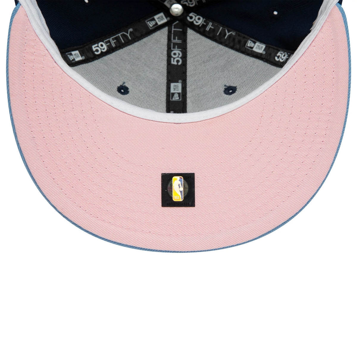 Memphis Grizzlies NBA Side Patch Dark Blue New Era 59FIFTY Fitted Cap, inside view showing light pink undervisor with an NBA logo sticker, grey sweatband and dark blue crown, detailed with branded taping along the interior seam.