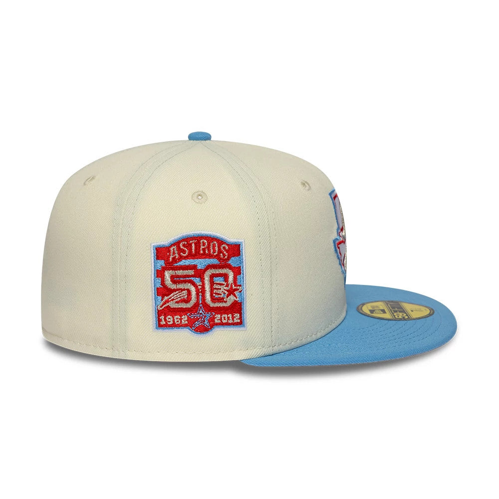 Houston Astros MLB Cooperstown Cream New Era 59FIFTY Fitted Cap, side view showing a red and blue Astros 50th anniversary embroidered patch on the cream crown, with a light blue flat visor and a gold 59FIFTY size sticker on top.