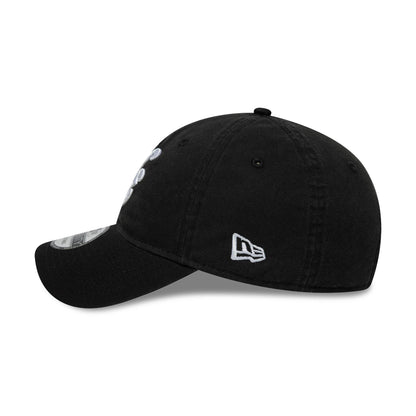 New Era Black 9TWENTY Adjustable Cap, side view showing the New Era flag logo embroidered in white on the left side, with a curved black visor featuring a 9TWENTY size sticker and a softly structured black crown.