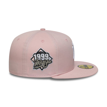 New York Yankees MLB World Series Pink New Era 59FIFTY Fitted Cap, side view showing the black and white embroidered 1999 World Series logo on the structured pink crown, with a flat pink visor and a gold 59FIFTY size sticker on the top.