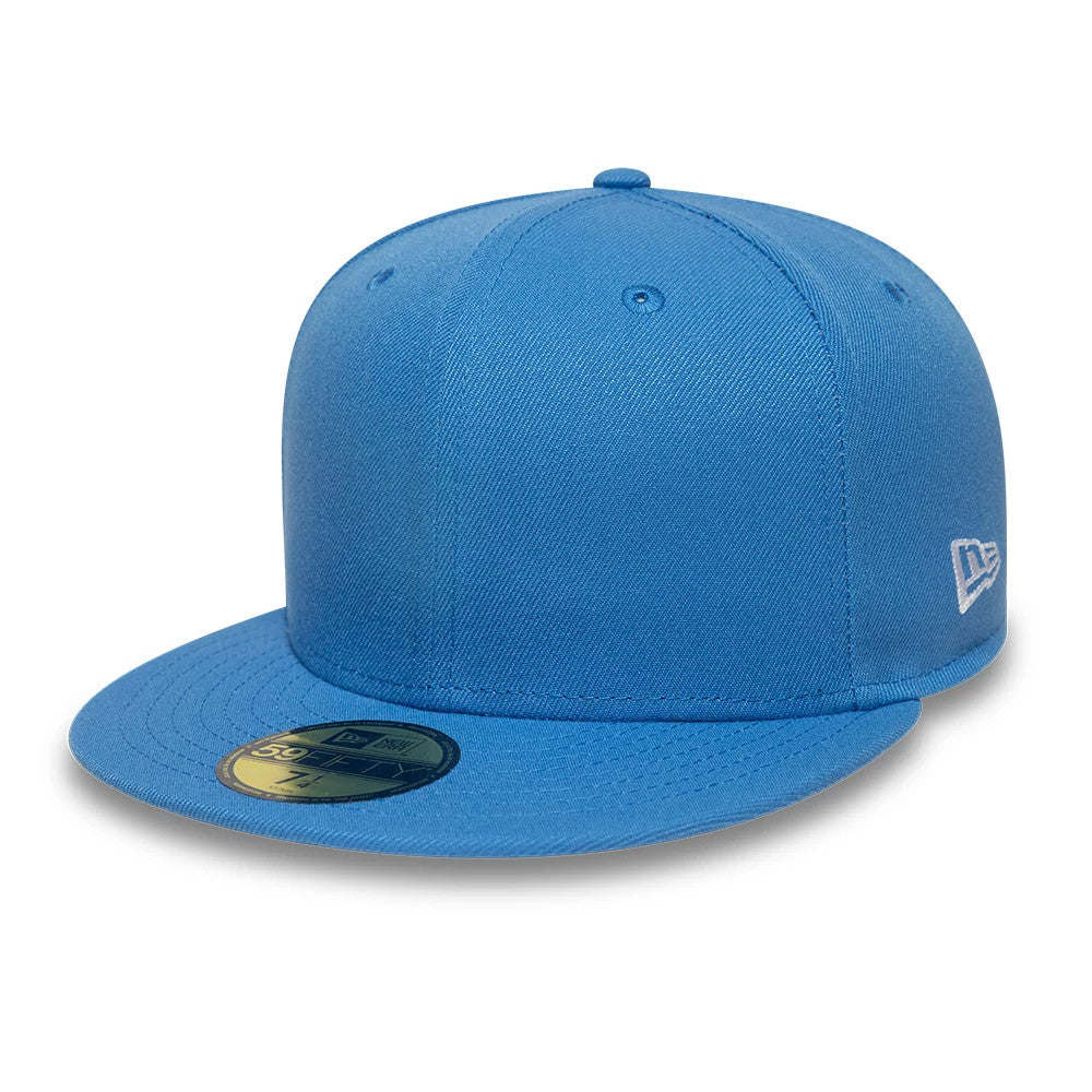 New Era Blue 59FIFTY Fitted Cap, three-quarter view showing a gold 59FIFTY size sticker on its flat blue visor, embroidered New Era flag logo on the left side, and matching top button and eyelets on the structured crown.