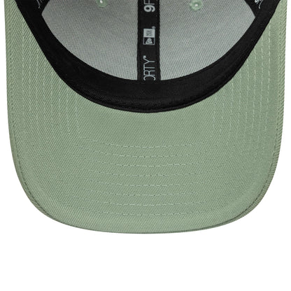 New Era Green 9FORTY Trucker Adjustable Cap, inside view showing the light green undervisor contrasted by a black sweatband, and interior taping marked with 9FORTY branding, offering an insight into the cap's structure with stitching.
