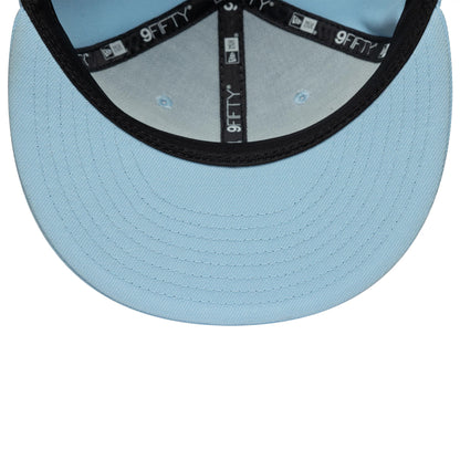New Era Blue 9FIFTY Snapback Adjustable Cap, inside view showing the light blue undervisor, black sweatband, and branded 9FIFTY taping across the structured crown, with blue eyelets on the interior panels.